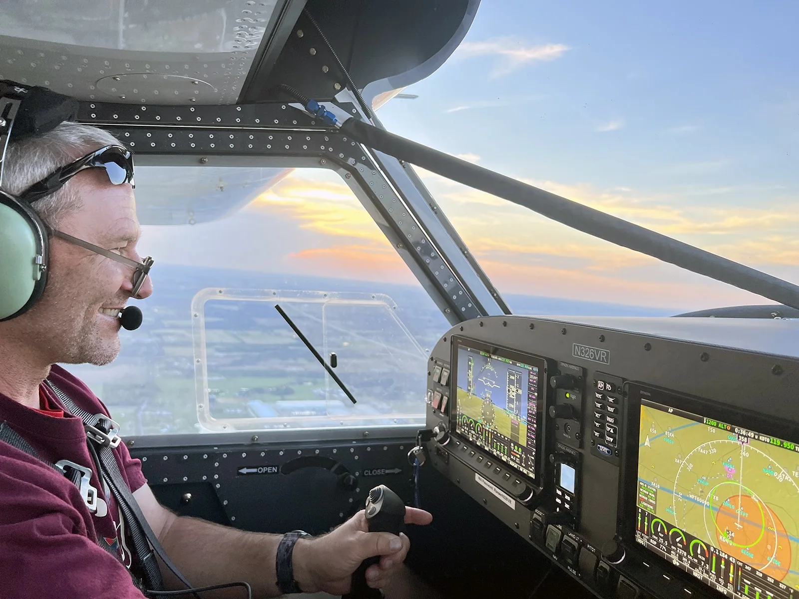 A pilot at the controls of an In The Pattern aircraft at sunset.
