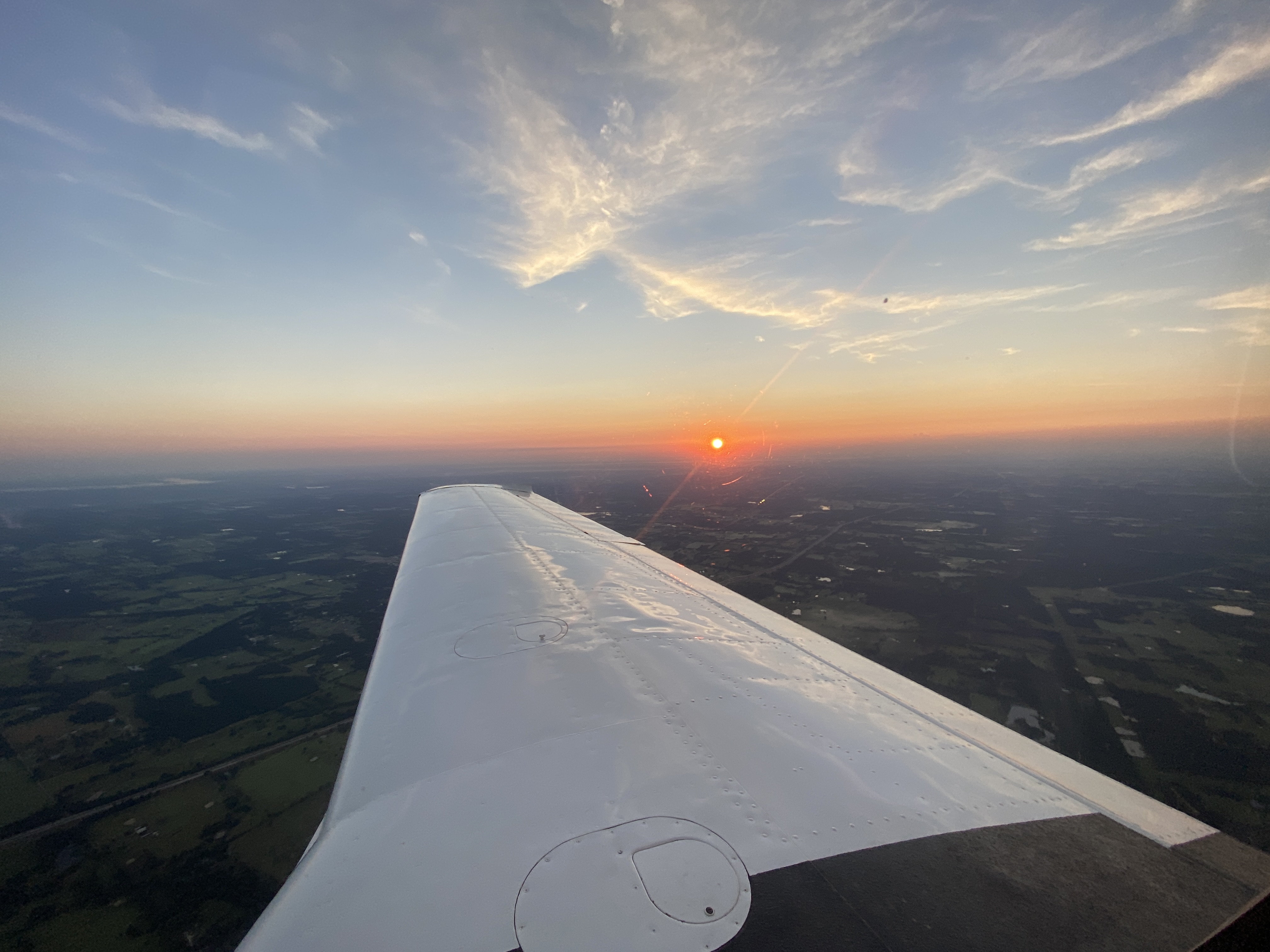 An aircraft wing against the evening sky at sunset.