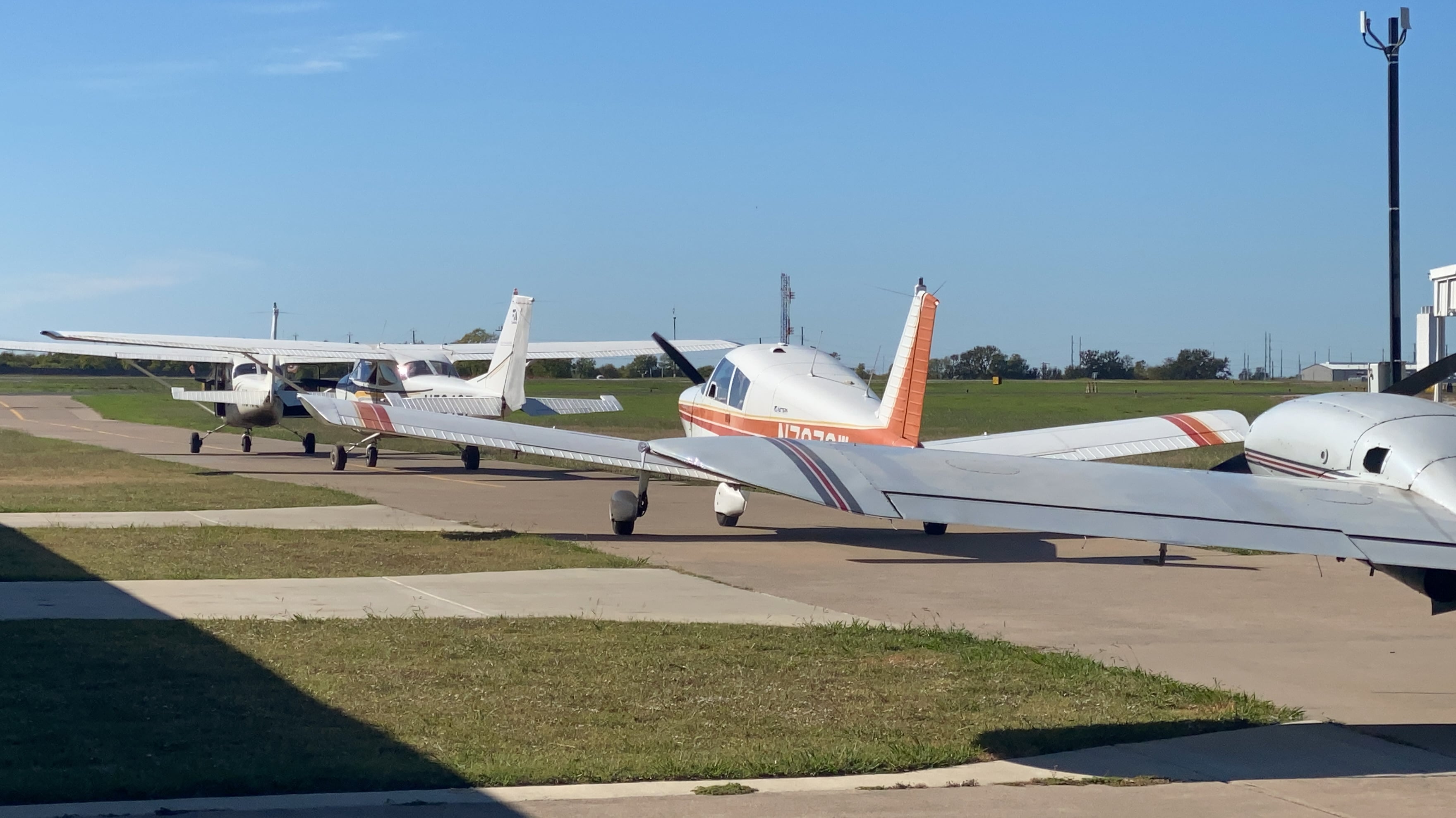 A lineup of light aircraft outside the hangar.
