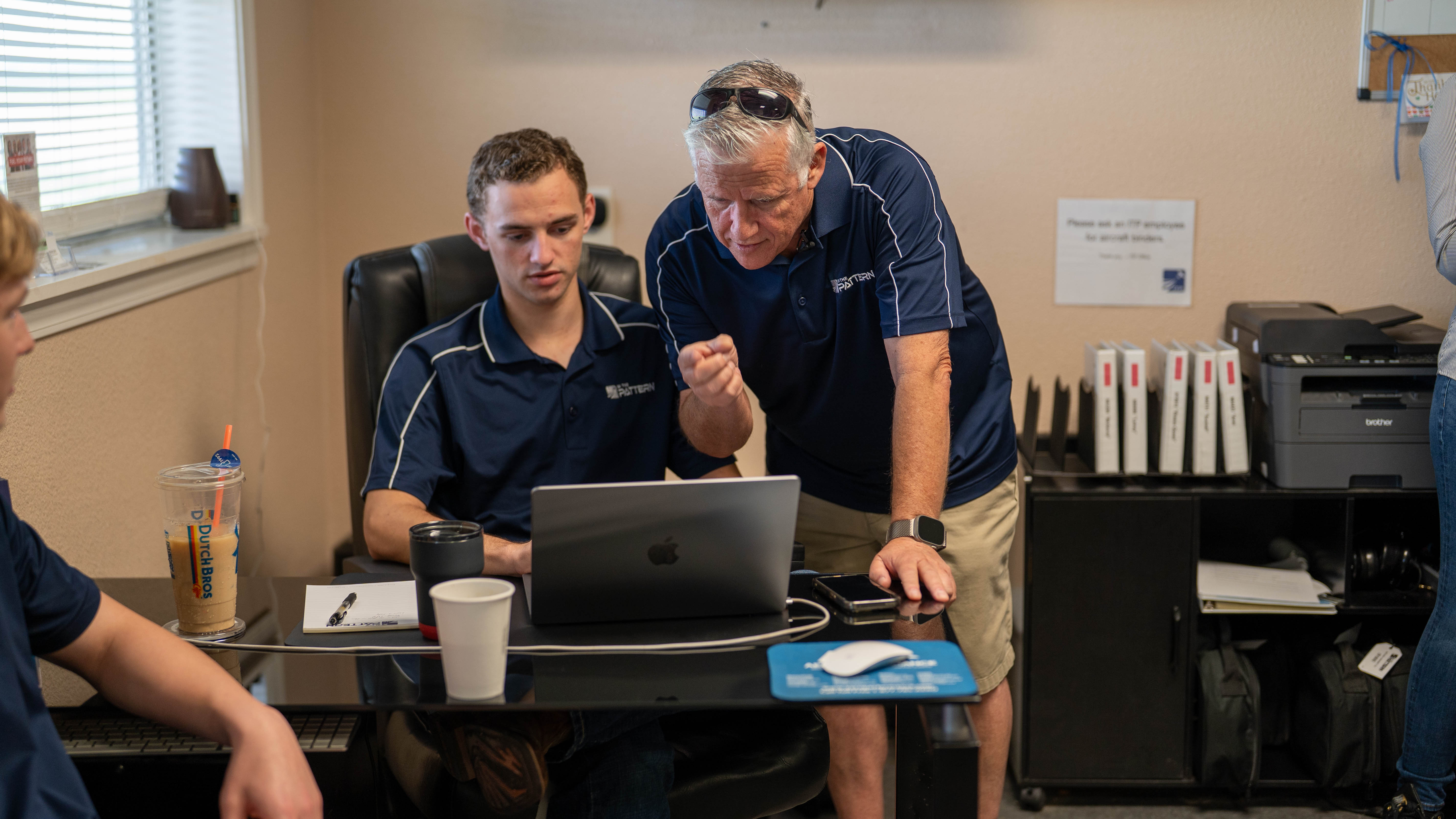 People reviewing information together at a desk in the flight school.