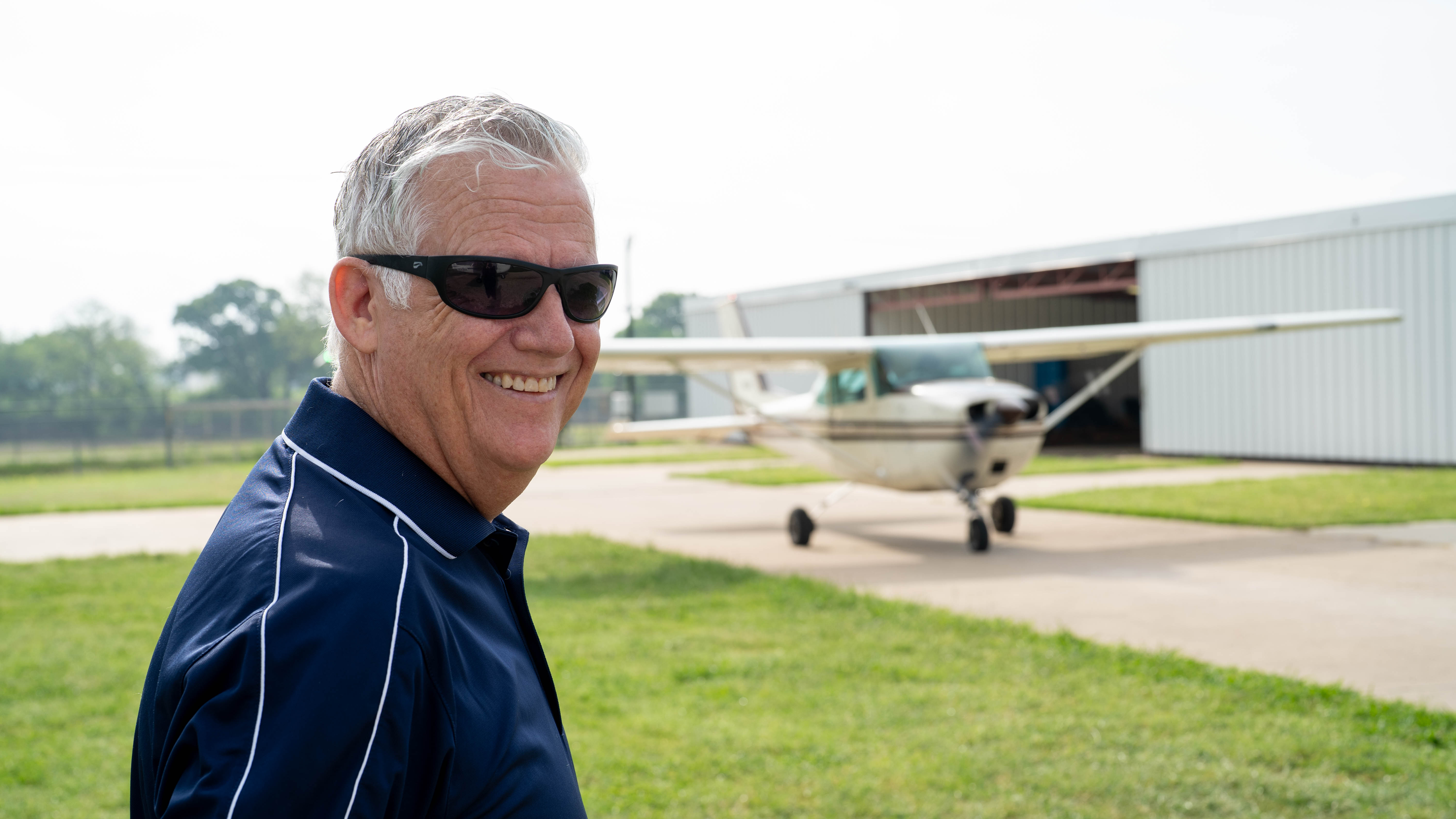A smiling member of the In The Pattern community outside the hangar.