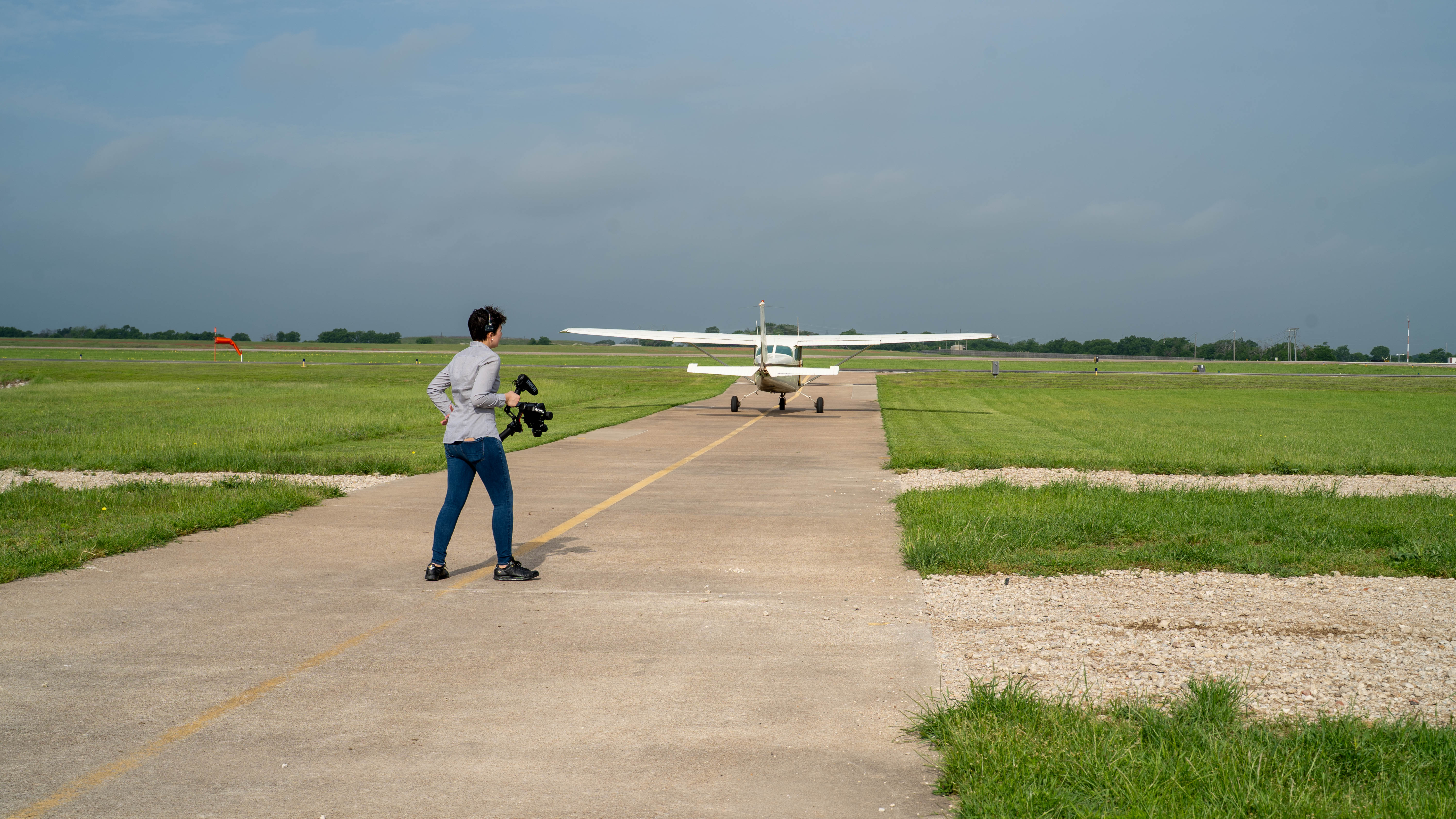A person walking toward a training aircraft on the apron.