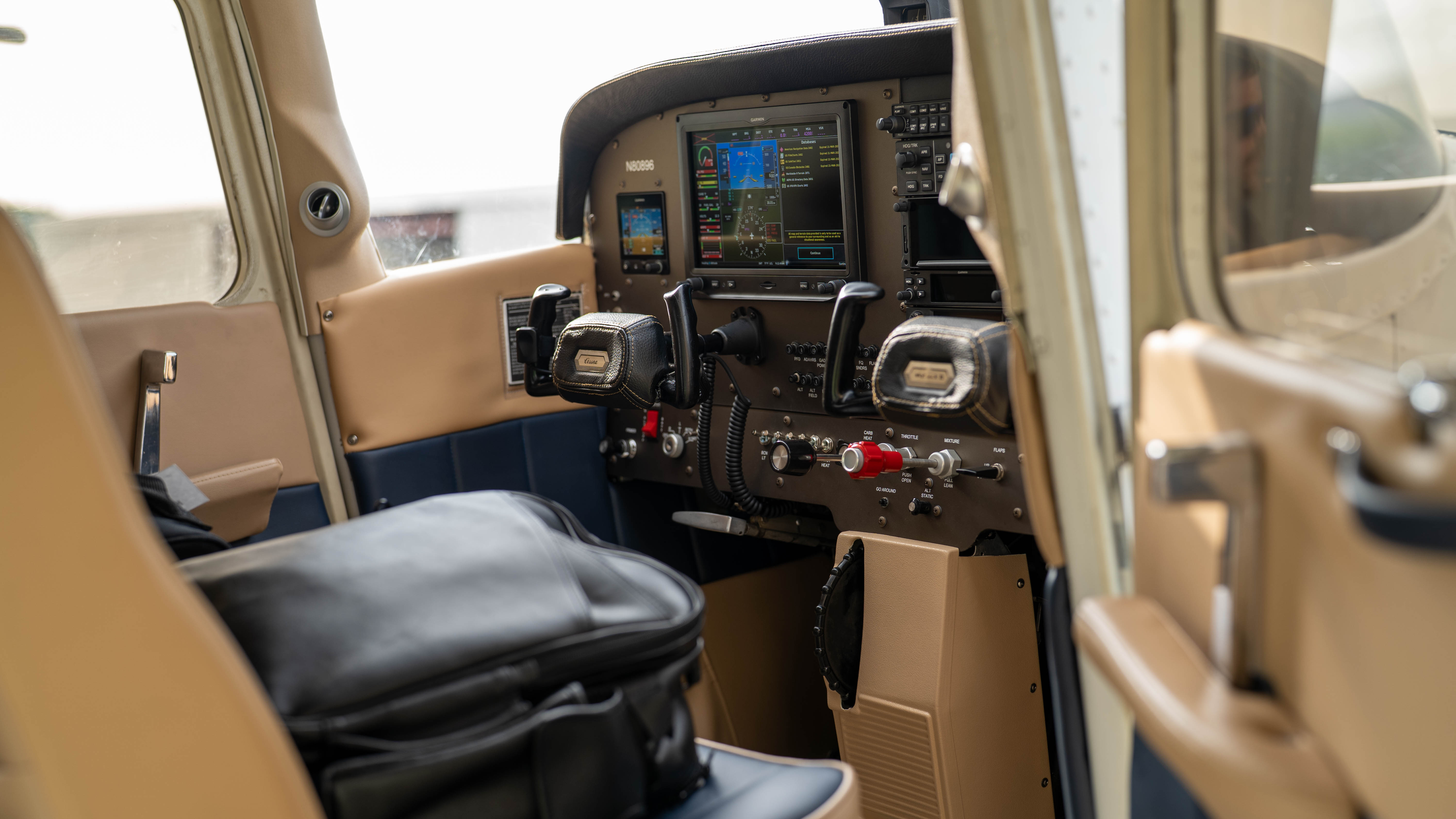 The open cabin doorway and controls of a training aircraft.