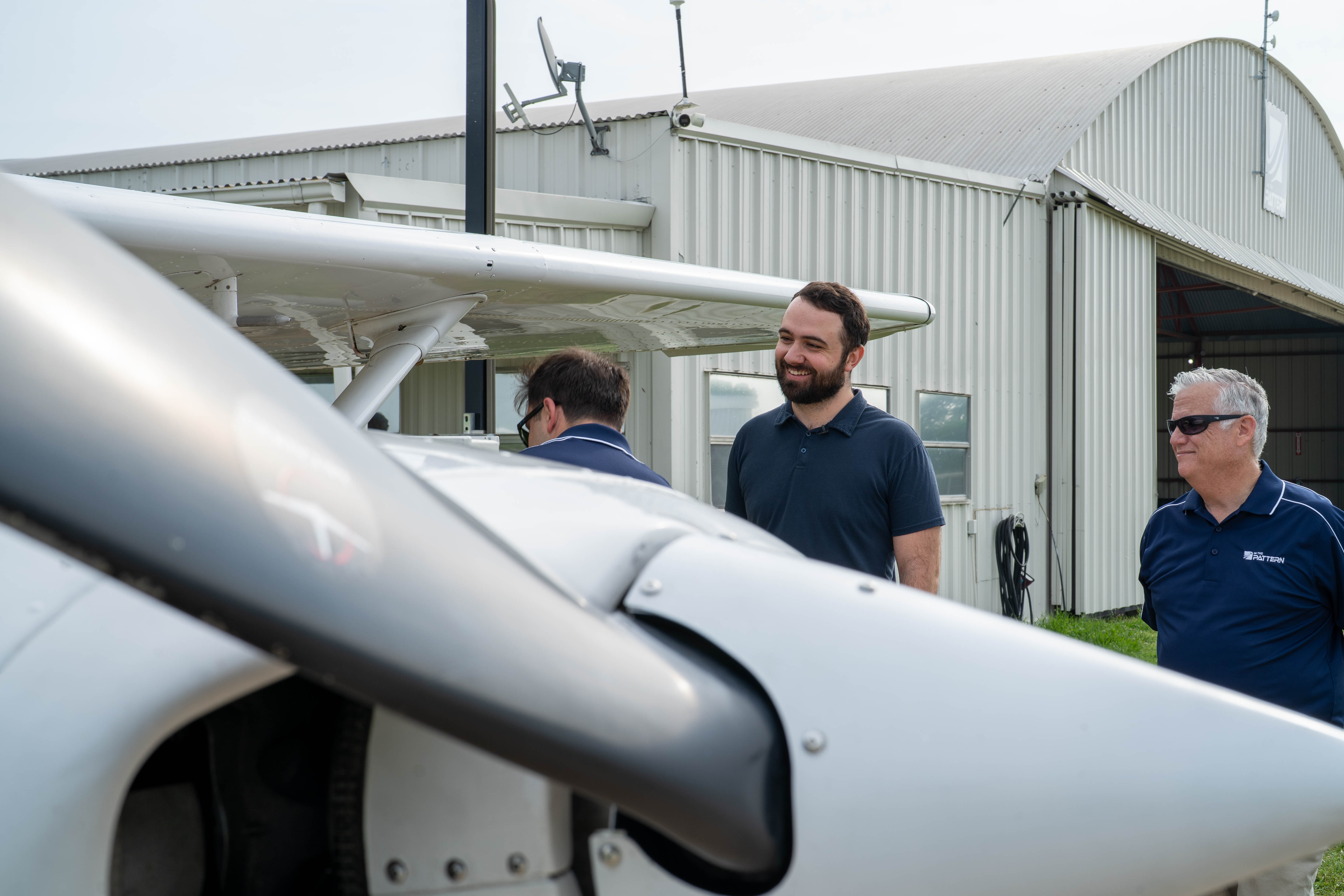 Two members of the flying community beside a training aircraft at In The Pattern.