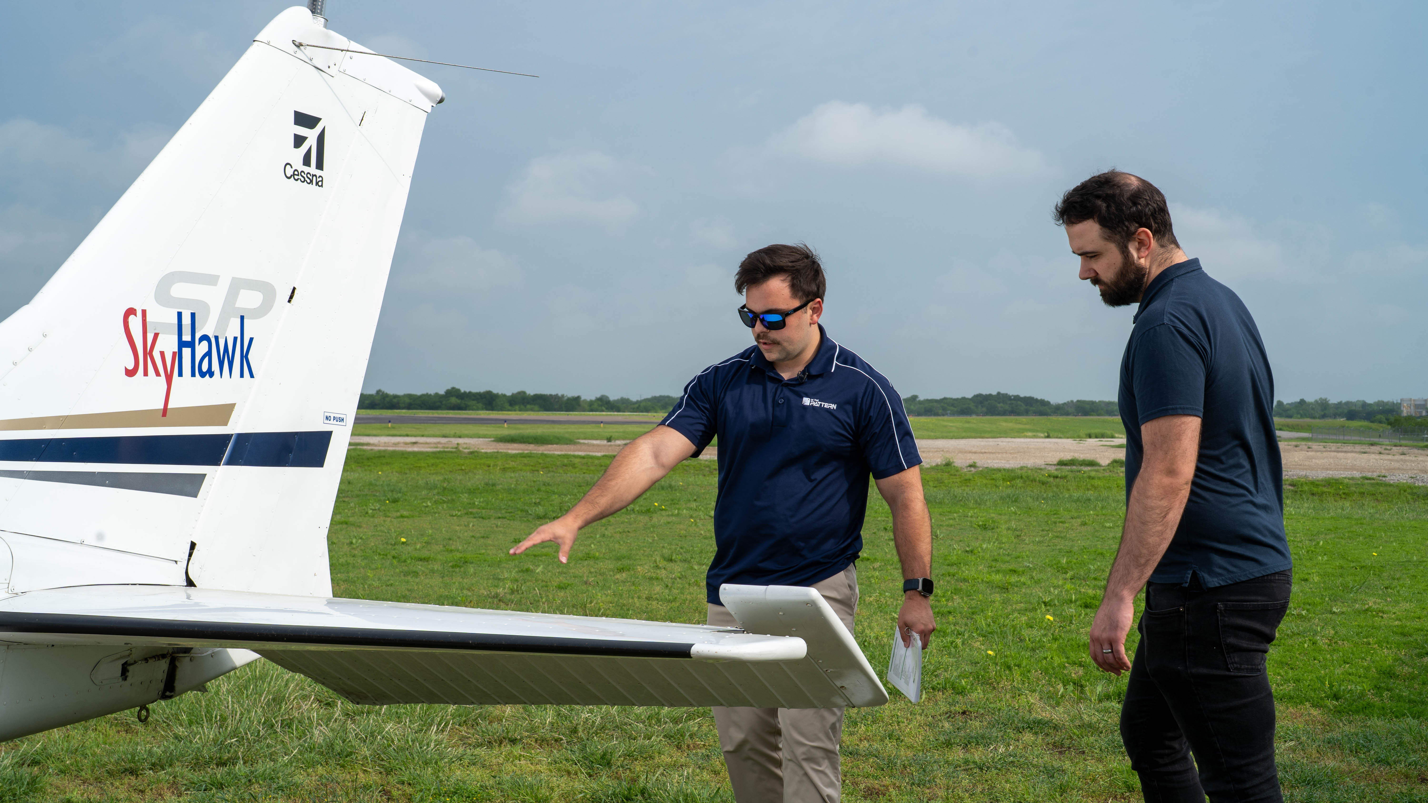 People examining a training aircraft during a preflight walkaround.