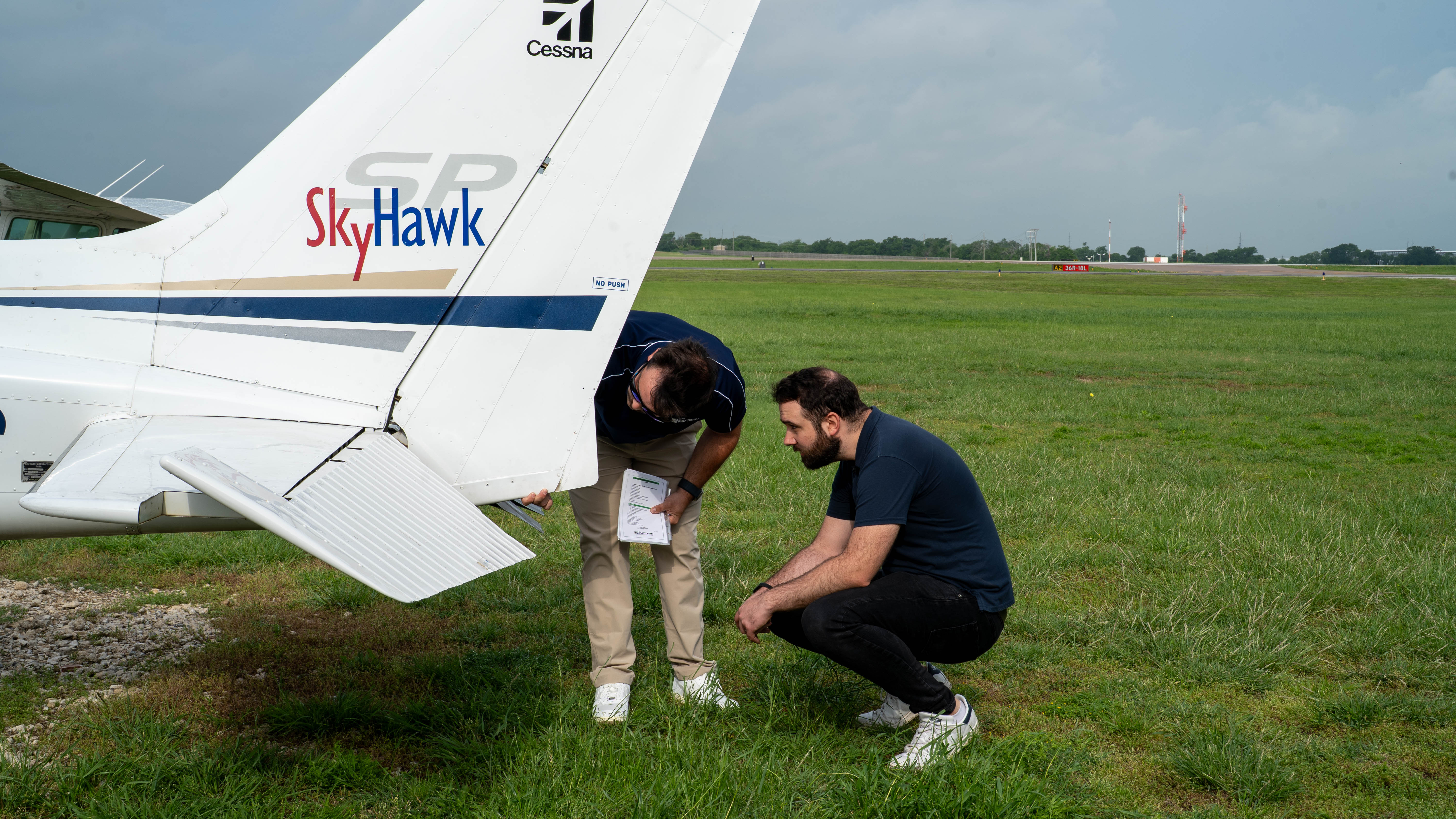 A person checking an aircraft wheel during a preflight inspection.