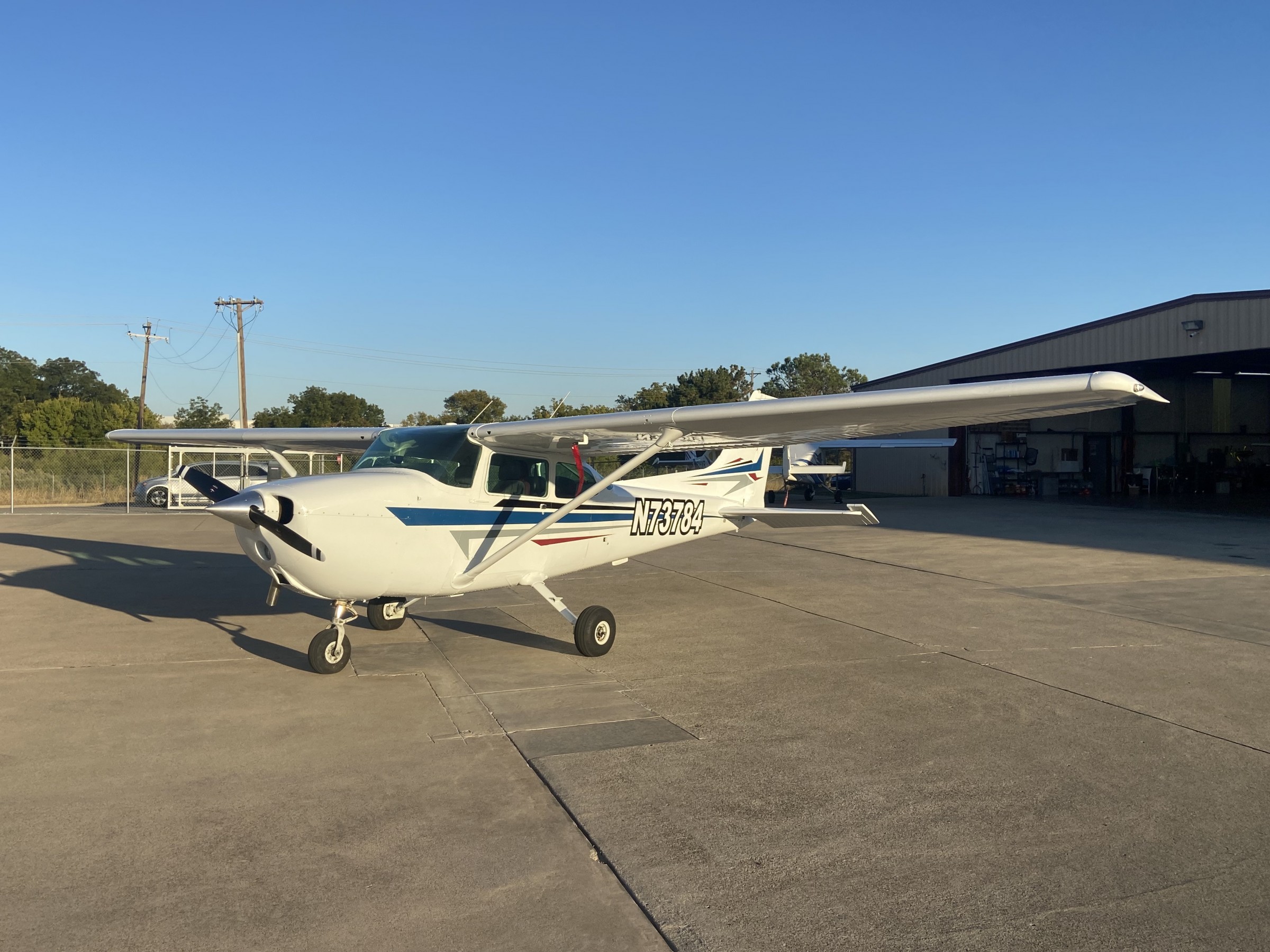 1977 Cessna 172 parked on an apron outside the school hangar.