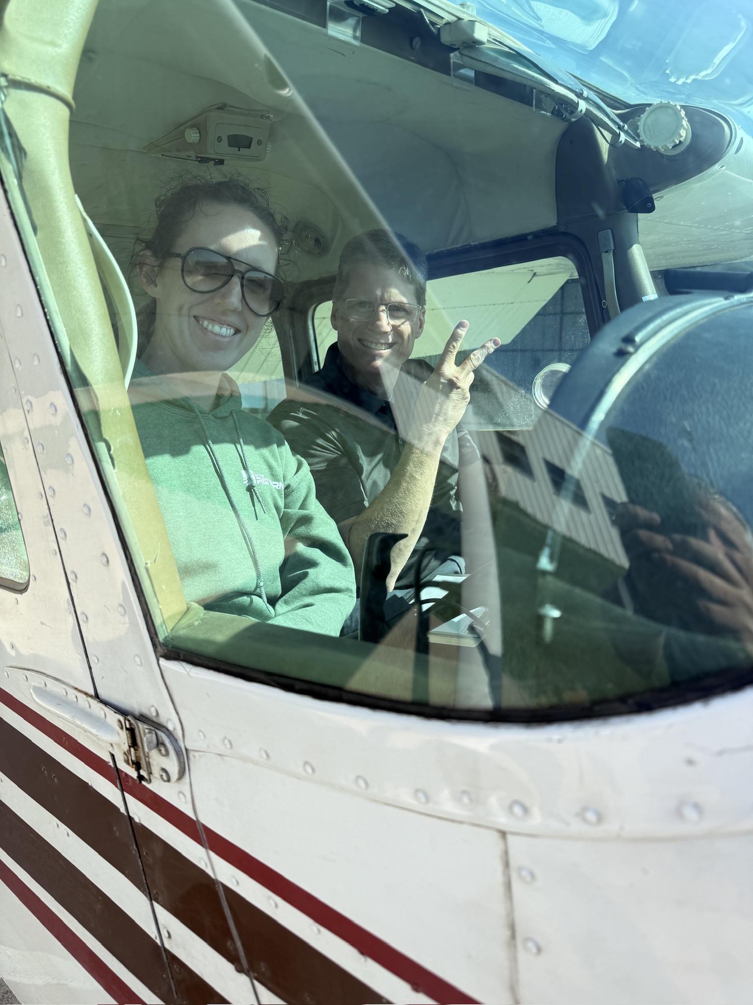 Emily and Darren smiling together through an aircraft window in ITP’s March 2026 story